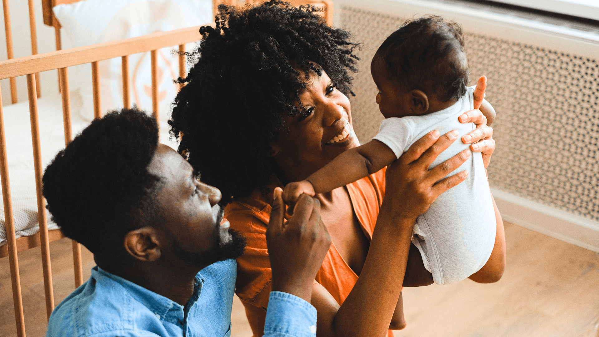 Young couple holding their baby and smiling