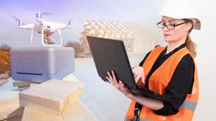 A woman in an orange vest holding a laptop.